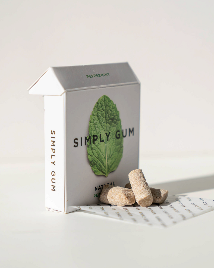 vitruta Simply Gum nane aromalı doğal sakız paketi ve yanında birkaç adet bitkisel bazlı sakız parçası